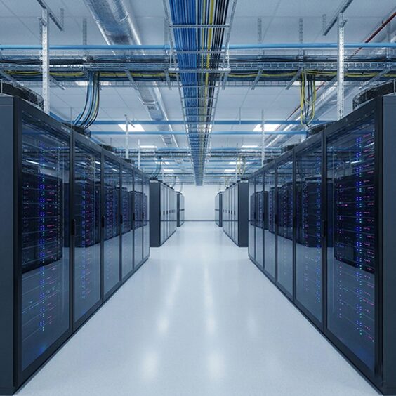 A data hall aisle between rack rows under dense overhead cable trays and ducting