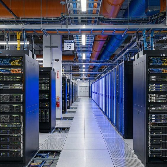 A long server aisle lit blue, racks receding to the far end