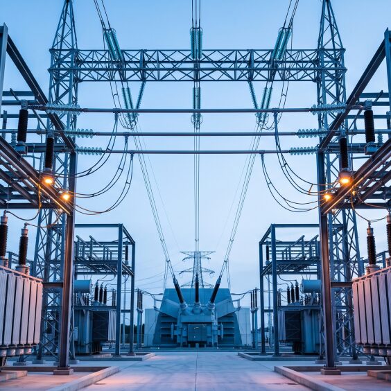 A high-voltage substation of transformers and gantries under open sky